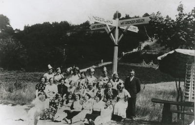 875488 Groepsportret van een vrouwenrijpot uit Wijk C te Utrecht, tijdens een uitstapje, bij een richtingbord op de ...